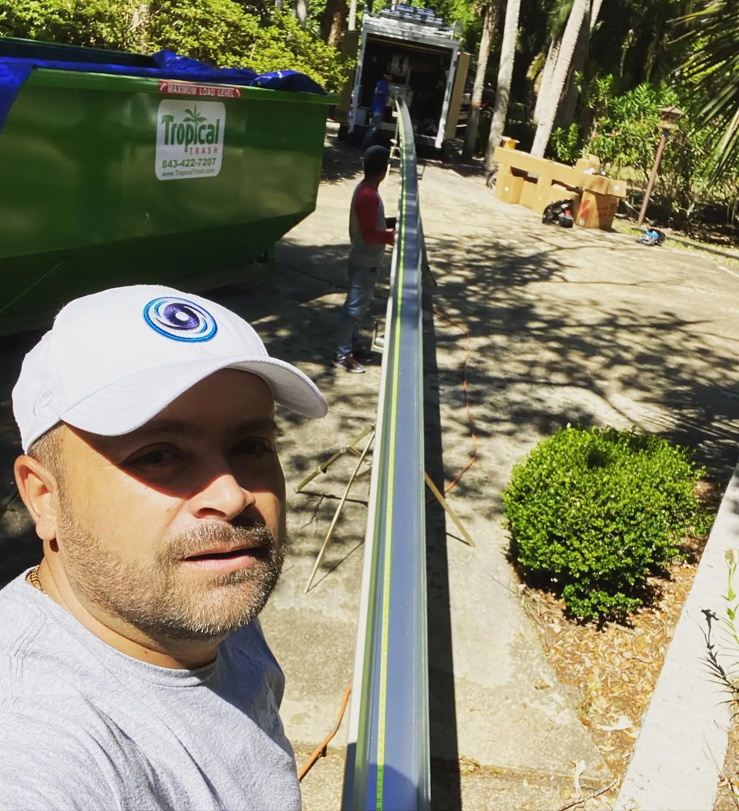 A&A Island Services crew member on a job site beside a long new seamless gutter section. Gutter cleaning, repair and installation in Bluffton, SC by A&A Island Services