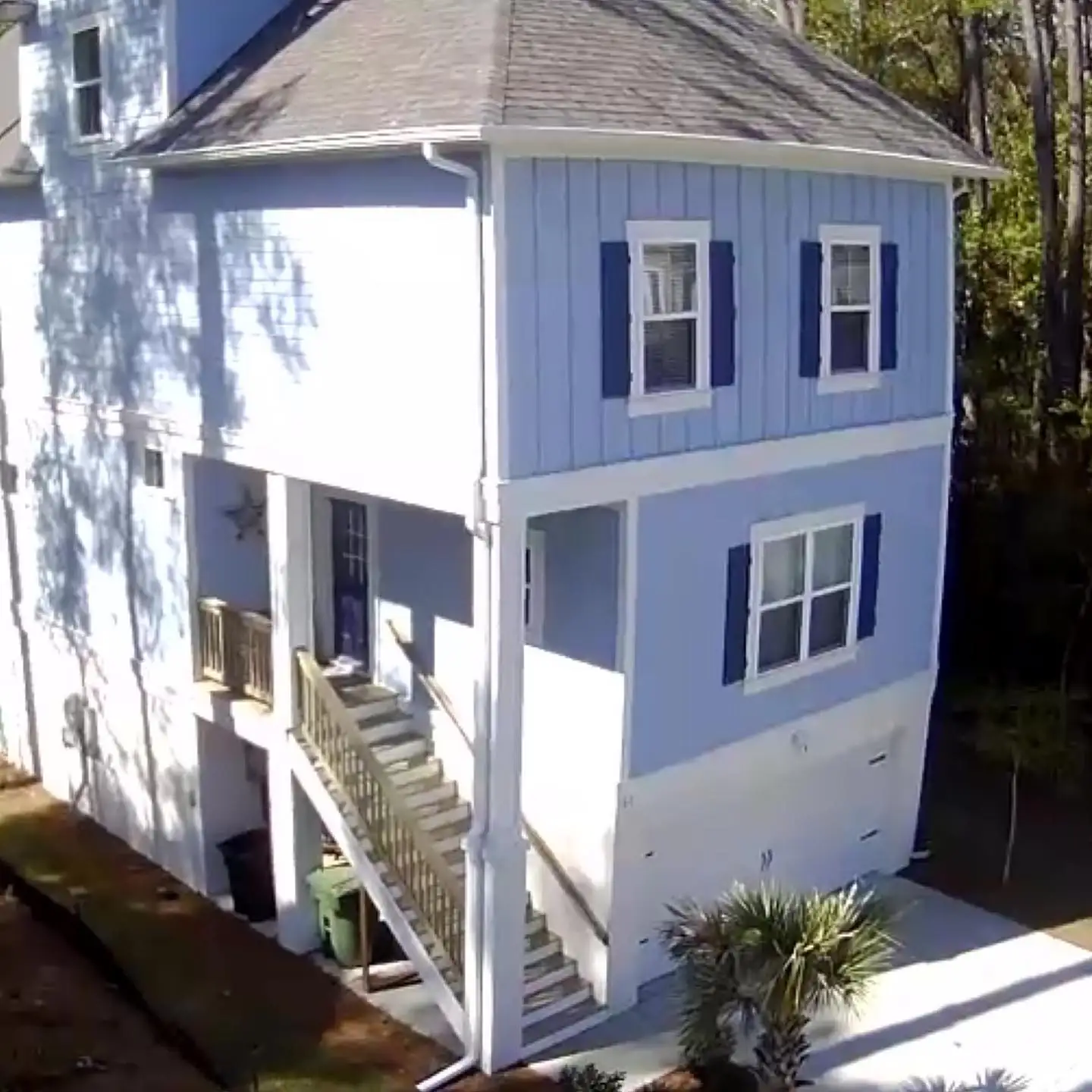 Blue three-story home with white trim, gutters and downspouts. Gutter Replacement in Bluffton, SC by A&A Island Services