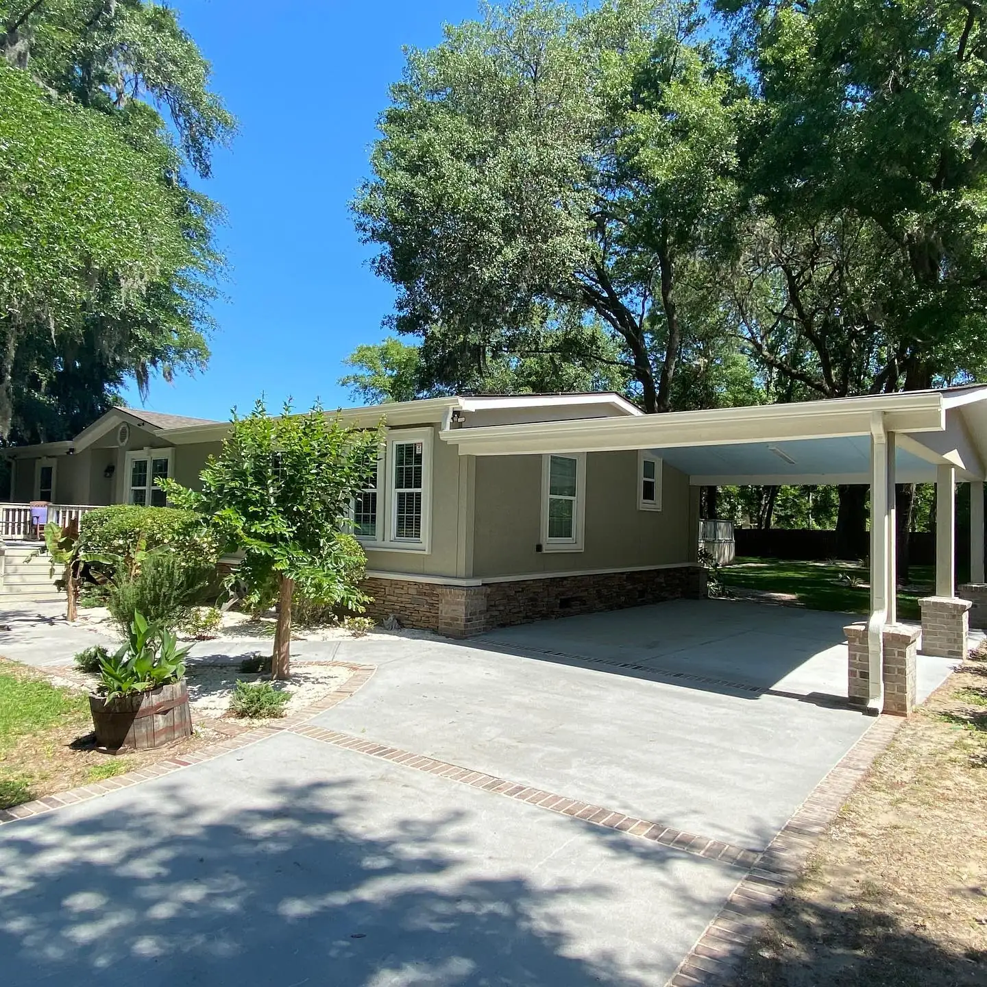 Single-story home and carport with gutters under large shade trees. Gutter services in Sea Pines, SC by A&A Island Services