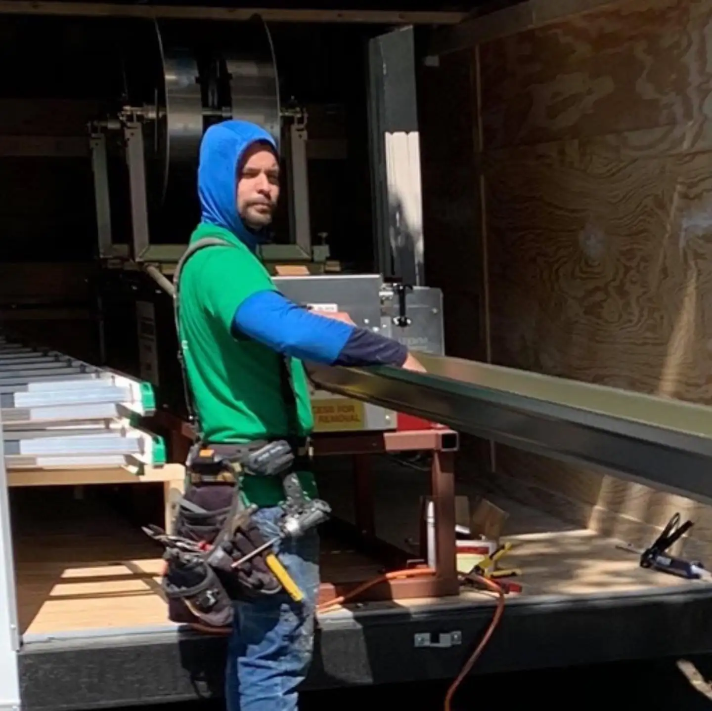 A&A crew member running a new seamless gutter through the forming machine in the trailer. Gutter cleaning and gutter installation in Bluffton, SC by A&A Island Services