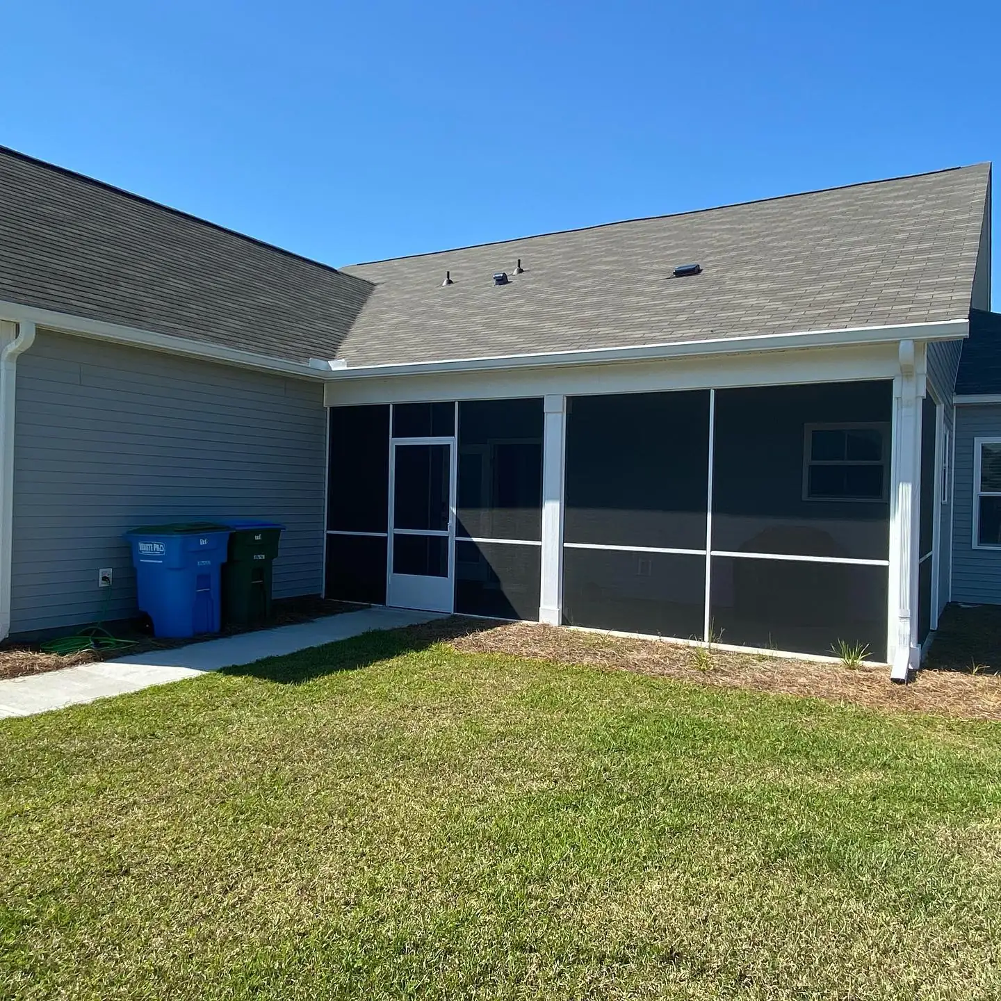 Gray home with a screened porch and white gutters. Gutter services in Pritchardville, SC by A&A Island Services