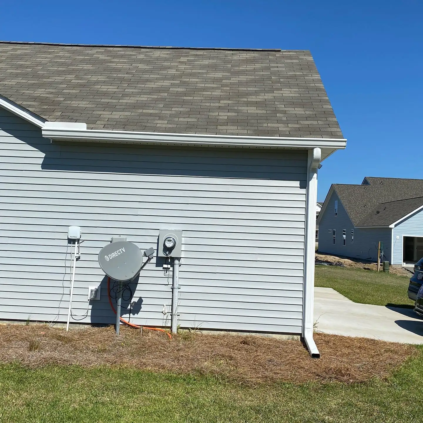 Side of a gray home with a white gutter and downspout. Gutter services in Pritchardville, SC by A&A Island Services