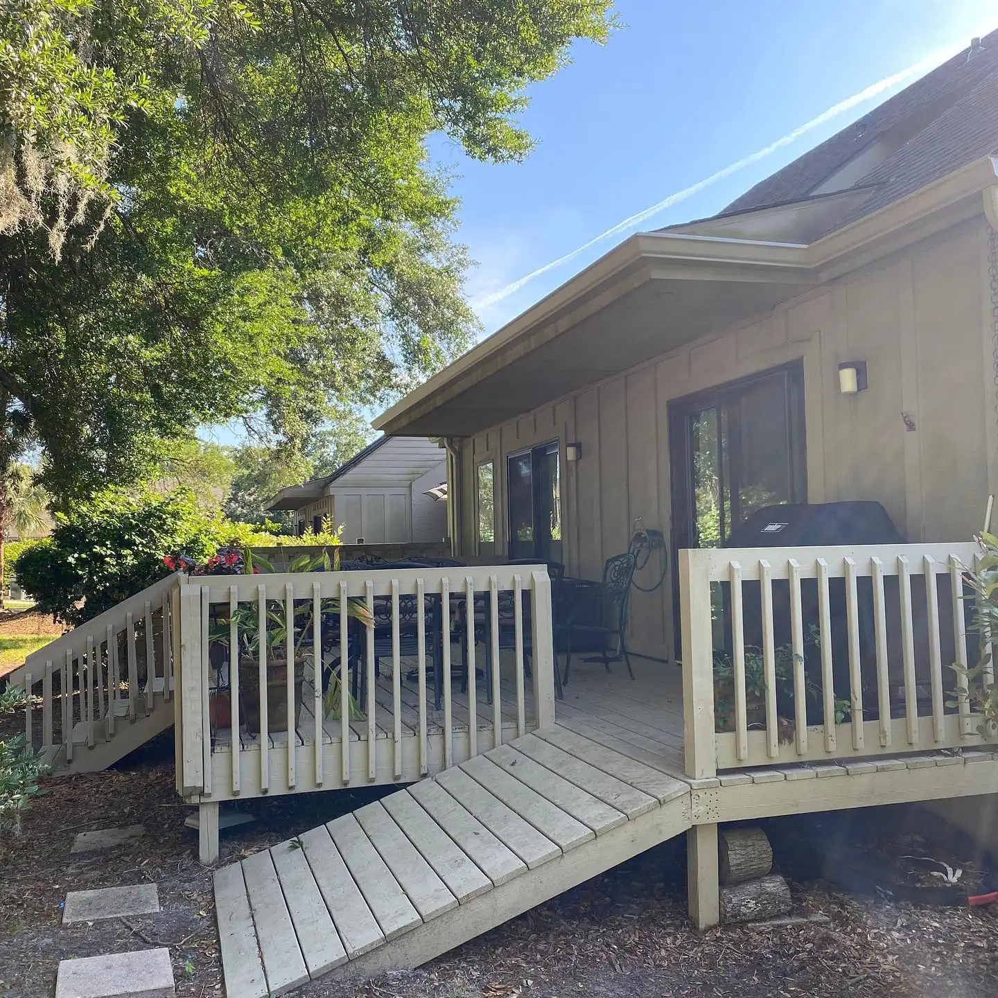 Back of a home with a wood deck and ramp and gutters along the roof. Gutter services in Sea Pines, SC by A&A Island Services