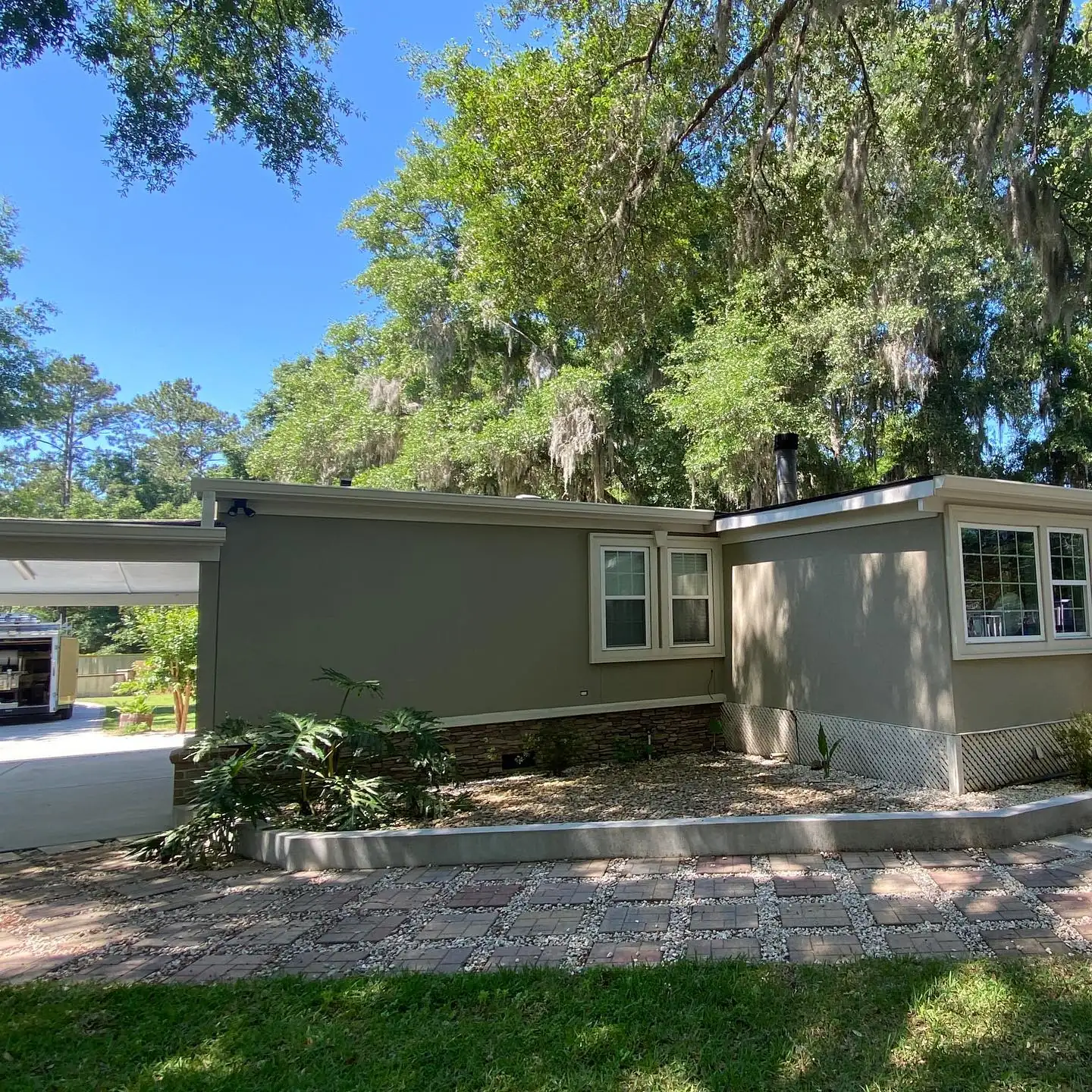 Single-story home with gutters under live oaks and Spanish moss. Gutter Cleaning in Ridgeland, SC by A&A Island Services