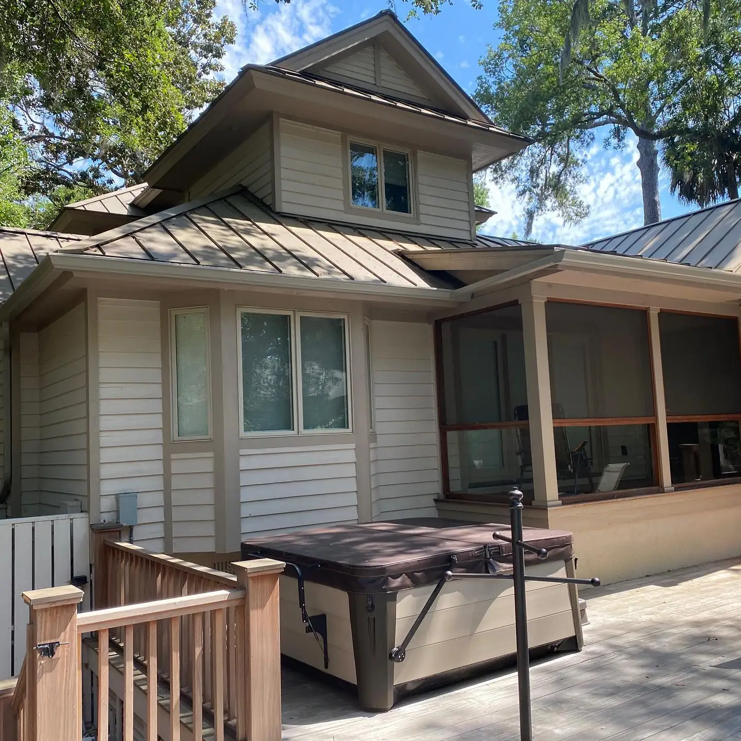 Home with a metal roof, gutters and a screened porch over a backyard deck. Gutter services on Daufuskie Island, SC by A&A Island Services