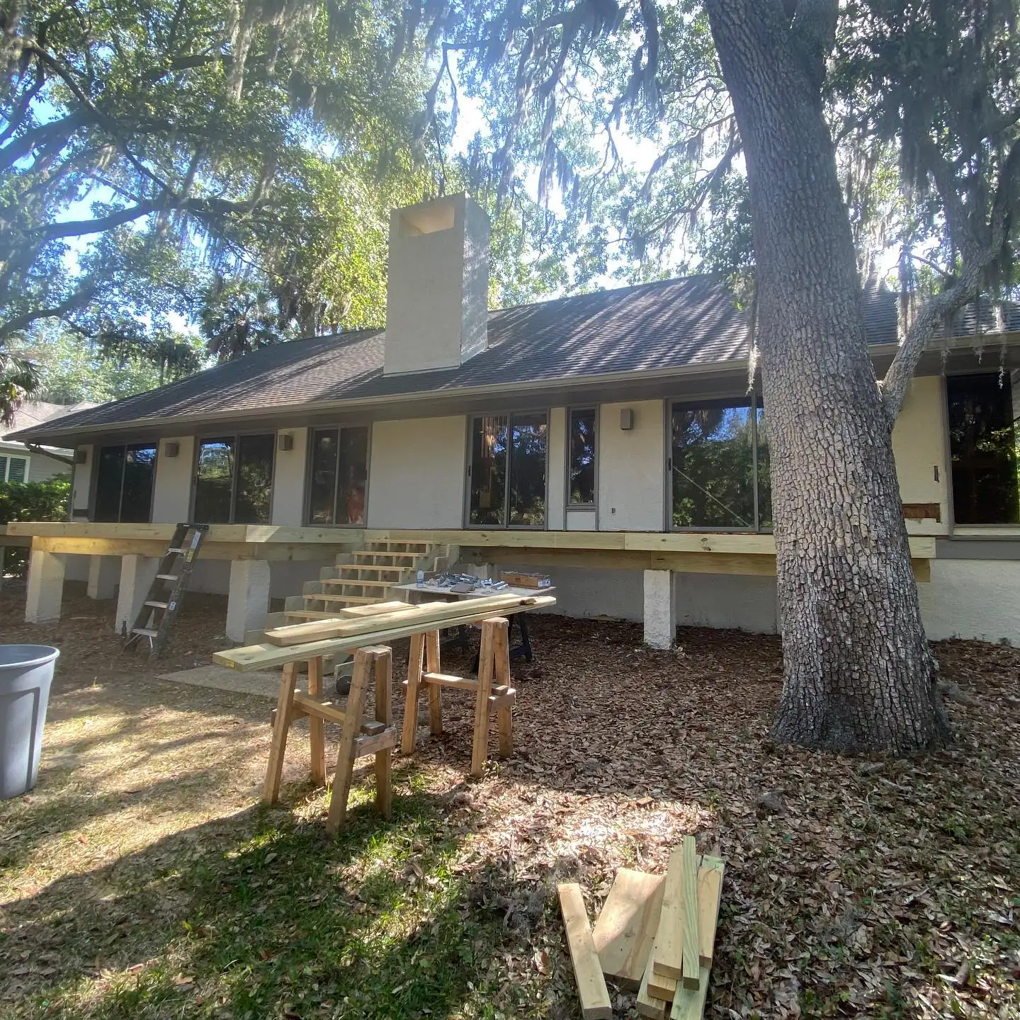 Raised home under a large live oak with gutters and a new deck stair. Gutter services in Hilton Head Plantation, SC by A&A Island Services