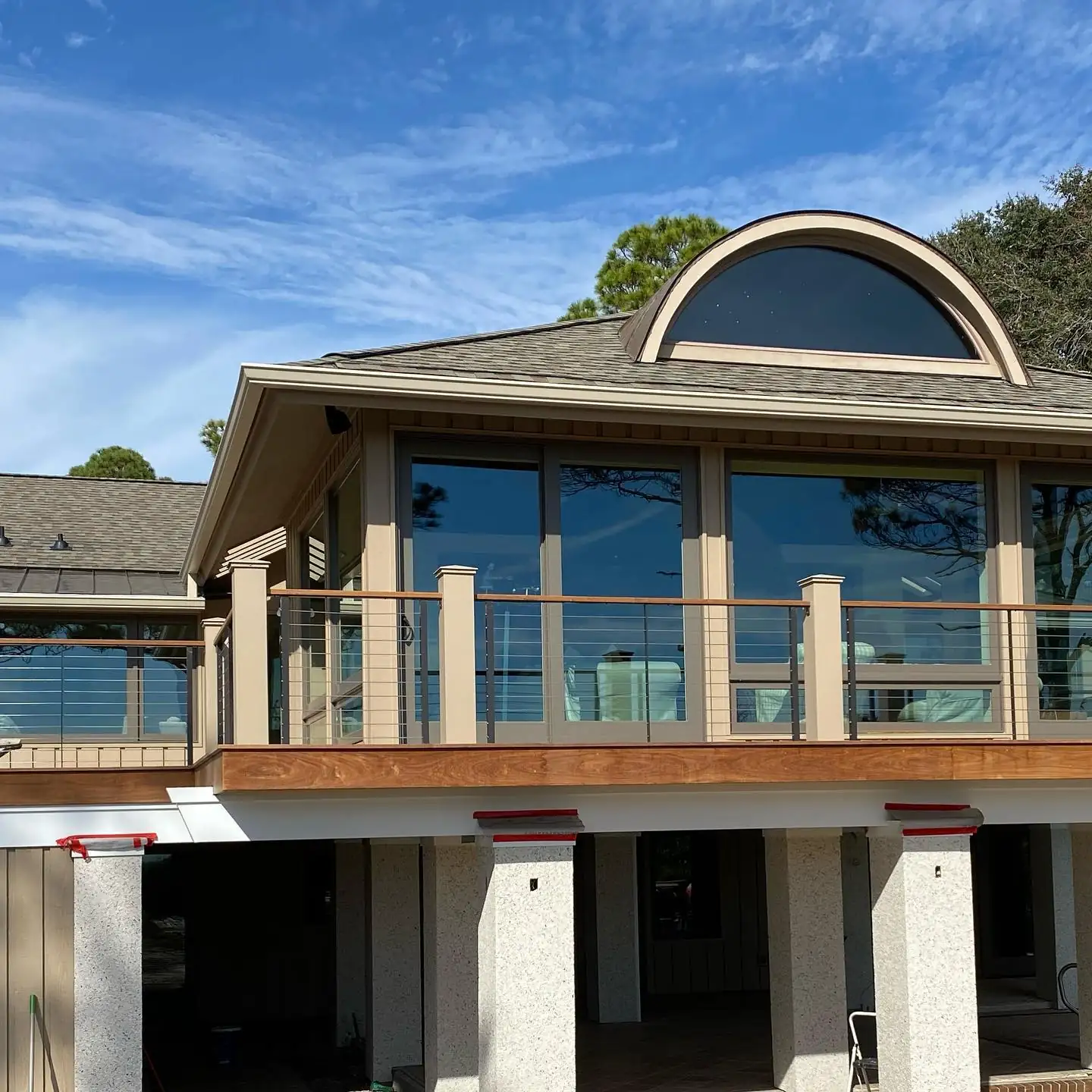 Raised Lowcountry home with a half-round window, a wall of windows and gutters. Gutter cleaning and gutter installation in Bluffton, SC by A&A Island Services