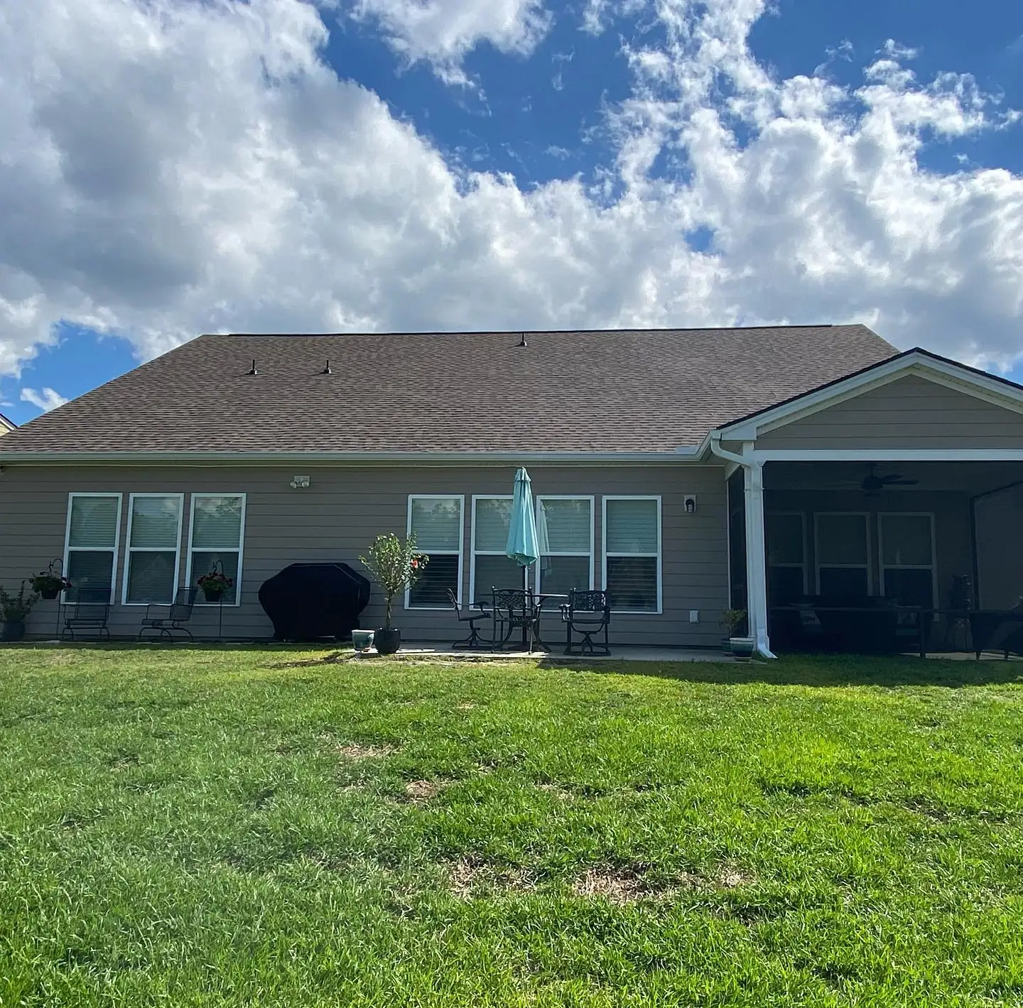 Back of a single-story home with gutters across a wide green lawn. Gutter Installation in Ridgeland, SC by A&A Island Services