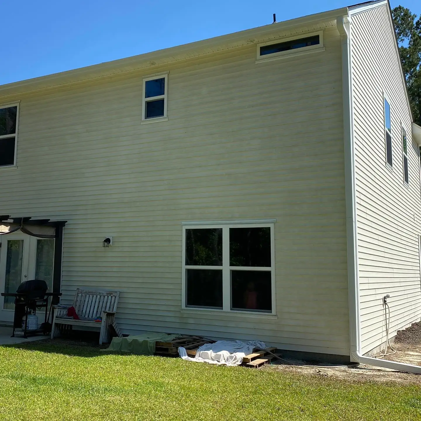 Side of a tan two-story home with white gutters. Gutter services on Daufuskie Island, SC by A&A Island Services