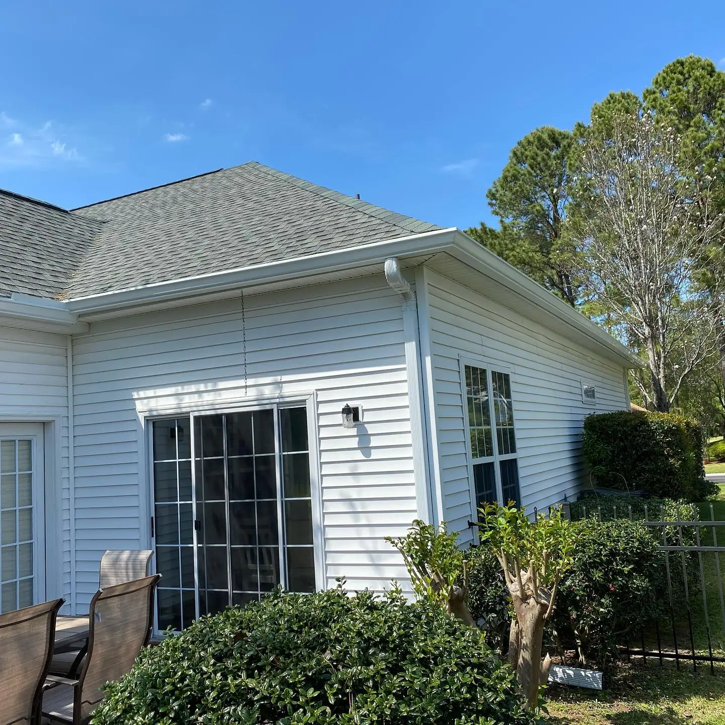 White home with gutters above a sliding glass patio door. Gutter services in Hilton Head Plantation, SC by A&A Island Services